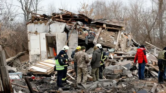 Rescue teams examine a damaged home in the Kyiv region 