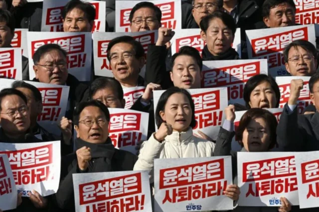 Lawmakers hold placards reading "Yoon Suk Yeol should resign" on 4 December