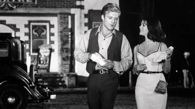 Robert Redford et Natalie Wood dans une photo en noir et blanc tirée du film Inside Daisy Clover. Ils marchent ensemble à l'extérieur.
