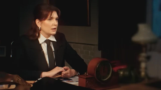 Одна з розслідувачок Єлизавета Сурначова за столом у затемненій кімнаті розповідає про результати розслідування