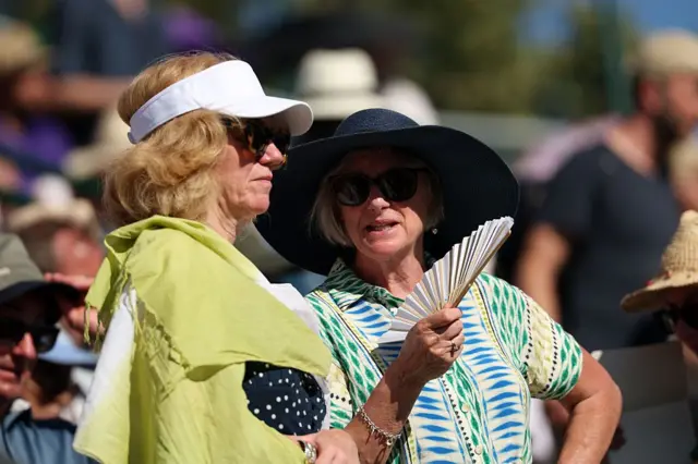 Widzowie wachlują się z powodu upalnej pogody pierwszego dnia turnieju tenisowego Wimbledon 2025