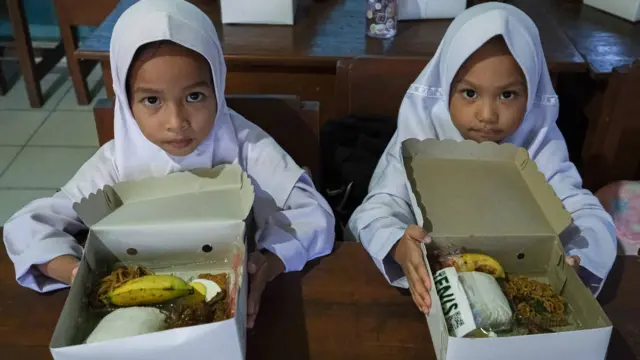 Dua murid SD menunjukkan makanan bergizi gratis di SDN 1 Kendari, Sulawesi Tenggara, Senin (18/11/2024). Peluncuran program pemberian makan bergizi gratis tersebut merupakan dukungan terhadap salah satu proram Asta Cita Pemerintah yang akan rutin diterapkan pada tahun 2025.