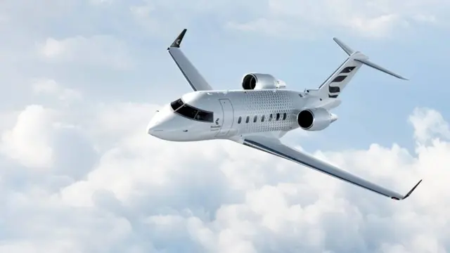 Bombardier Challenger 650 executive jet လေယာဥ်ကို လေမှာ ပျံဝဲနေတာတွေ့ရပါတယ်။ မိုးပြာရောင်ကောင်းကင်မှာ တိမ်စိုင်တွေက ဝါဂွမ်းလိပ်တွေလို ဖြစ်နေတာပါ။
