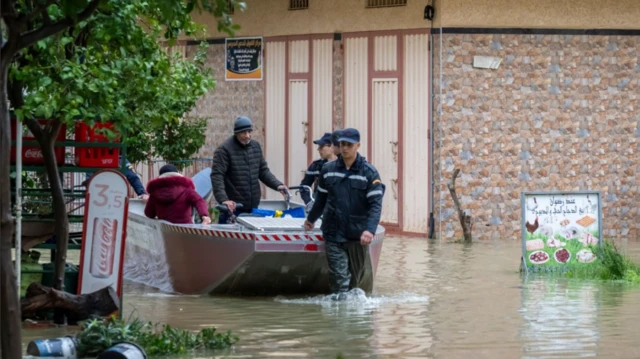 مسؤولو الحماية المدنية يقومون بإجلاء السكان من منازلهم بعد أن غمرت المياه المنازل في قصر الكبير بالمغرب، في 30 يناير/ كانون الثاني 2026