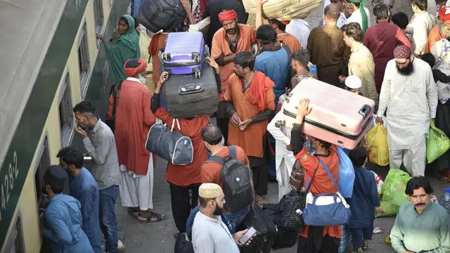 Train at railway station while many are trying to get onboard with their luggage