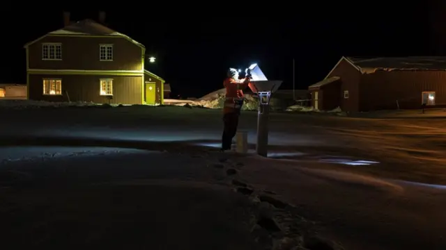 Person looking into an instrument outside a research station