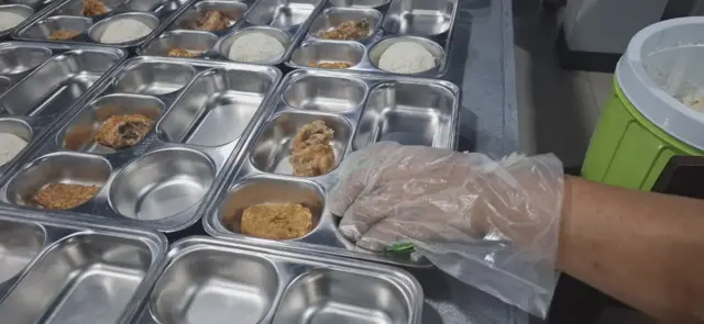 Salah seorang petugas dapur umum Yayasan Sinar Mentari Sejati yang dikelola Eddy Lau menyiapkan paket MBG di Kupang, Nusa Tenggara Timur pada Selasa (18/11).