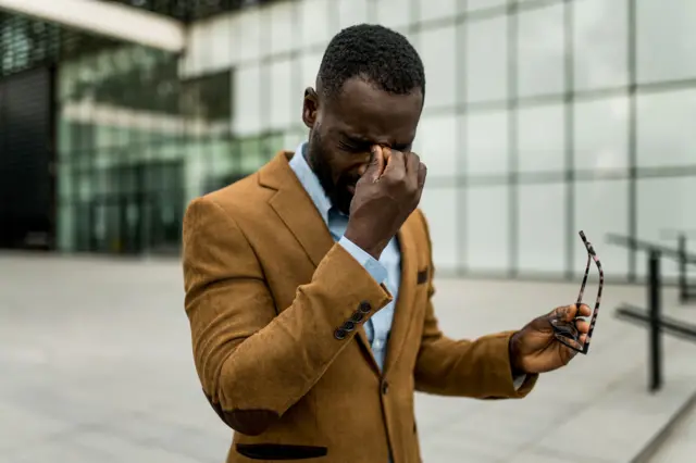 Homme qui se tient les yeux