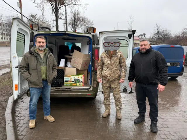 Сергій Гайдай (ліворуч) і Олексій Кузнєцов (праворуч) під час передачі допомоги військовим ЗСУ