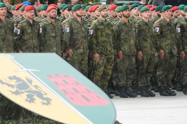 Немецкие военные, на первом плане — герб бригады.