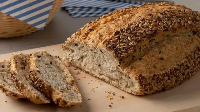Cette image montre un pain multigrains aux graines, communément appelé pain de campagne ou pain au levain.