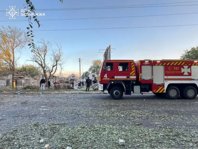 пожежна машина на фоні руїн будинків