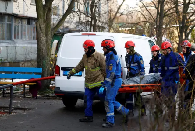 Спасатели выносят тело погибшего после ночного удара по Киеву