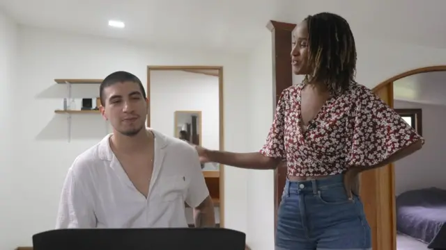 La imagen muestra a Monifa Miller parada junto a Sebastián Correa, un músico argentino quien también emigró a Costa Rica.