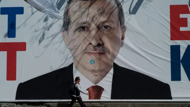 İstanbul'da 16 Nisan 2017'deki anayasa değişikliği referandumundan bir gün önce çekilmiş bir fotoğraf. Cumhurbaşkanı Erdoğan'ın olduğu büyük bir poster görülüyor. Posterin üzerine "Hayır" çıkartmaları yapıştırılmış. Önünden bir kadın yürüyor.