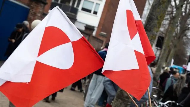 Un manifestante porta la bandera de Groenlandia durante una manifestación contra la administración Trump.
