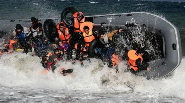 چند نفر در قایقی که آب وارد آن شده است. امواج بزرگی در اطراف قایق دیده میشود