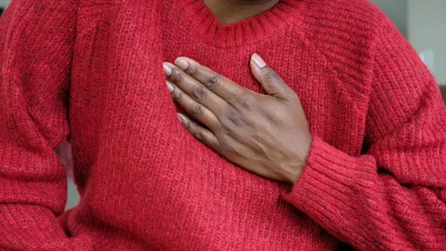 له نژدې څخه د یوې ښځې انځور اخیستل شوی، چې سینه کې د درد له کبله یې هغې پورې لاس کلک نیولی دی.