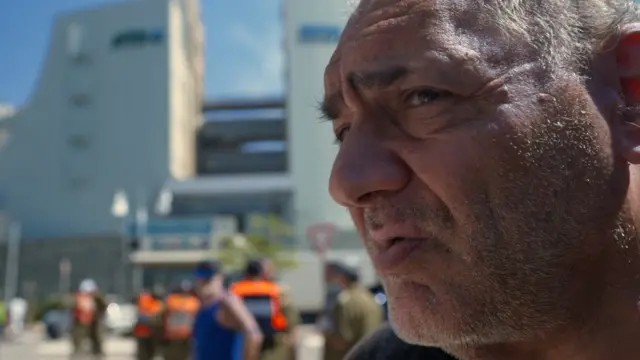 Man being interviewed outside Israeli hospital 