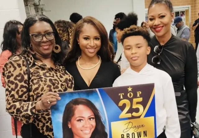 졸업생 시상식에서 상을 들고 있는 브라운과 가족들의 모습