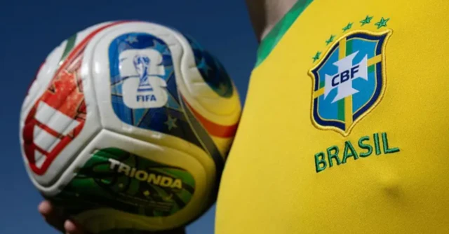 Camisa da Seleção Brasileira, amarela, com um homem segurando uma bola de futebol colorida