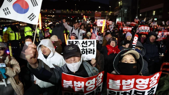Orang-orang yang mendukung Presiden Yoon Suk Yeol berkumpul di dekat kediaman resminya untuk mencoba menghentikan penyelidik badan antikorupsi Korsel yang berupaya menahan Yoon pada 3 Januari 2025.