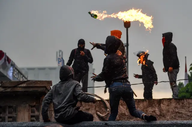 Massa aksi melemparkan molotov saat aksi di Depan Gedung DPRD Jawa Barat di Bandung, Jawa Barat, Jumat (29/8/2025). 