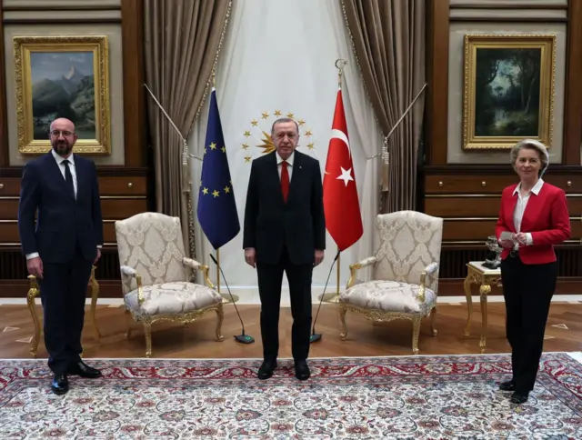 Von der Leyen, Erdoğan ve Charles Michel iki koltuğun önünde ayakta duruyor.