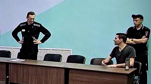 Na ekranie widać uwięzionego rosyjskiego opozycjonistę Aleksieja Nawalnego (po lewej), oczekującego na ogłoszenie wyroku w sprawie zarzutów o ekstremizm. Nagranie pochodzi z kolonii karnej IK‑6 — więzienia o zaostrzonym rygorze położonego około 250 kilometrów na wschód od Moskwy, w miejscowości Melechowo w obwodzie włodzimierskim — z 4 sierpnia 2023 r.