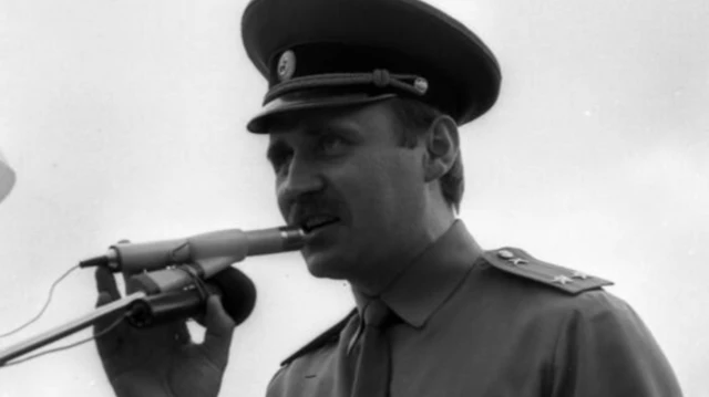 Николай Статкевич на митинге с микрофоном. На нем военная форма советского образца