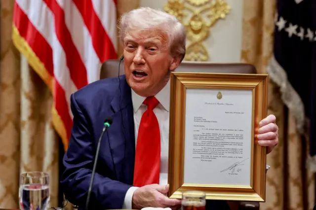 Donald Trump trzyma oprawiony list od prezydenta Argentyny, Javiera Milei, w którym Milei wyraża poparcie dla jego kandydatury do Pokojowej Nagrody Nobla. 14 października 2025 r. 