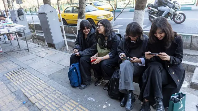 یک تصویر از چهار دانشجوی زن که در شنبه ۲ اسفند ۱۴۰۴ در تهران کنار خیابان نشسته و مشغول کار با تلفن‌های همراه‌شان هستند. در هفته‌های اخیر ایالات متحده حضور نظامی خود را در اروپا و خاورمیانه افزایش داده است که باعث تقویت گمانه‌زنی‌ها درباره تمایل واشینگتن به اقدام نظامی علیه ایران شده است.