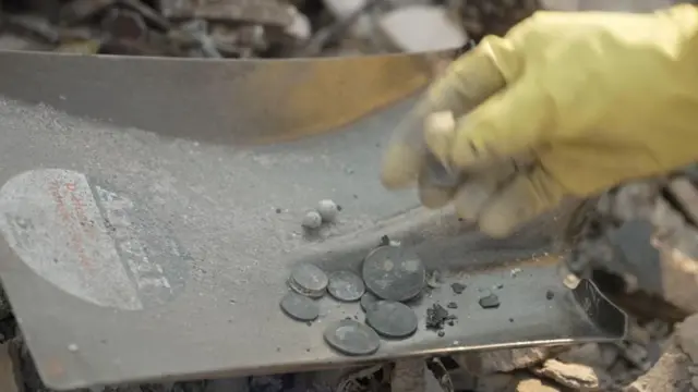 राख में अपनी चीज़ें तलाशते लोग