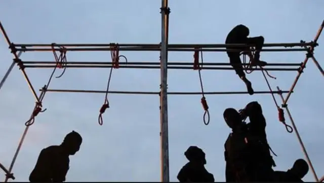 منصة إعدام عليها عدد من الأشخاص.