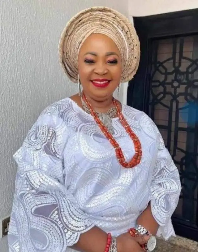 |Dupe Adeleke Sanni wọ asọ iro ati buba funfun, o we gele Sanyan, o si fi ilẹkẹ ati ẹgba sọrun ati eti rẹ