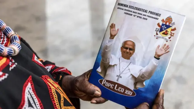 One woman hand hold di magazine wey show di Pope visit for Cameroon