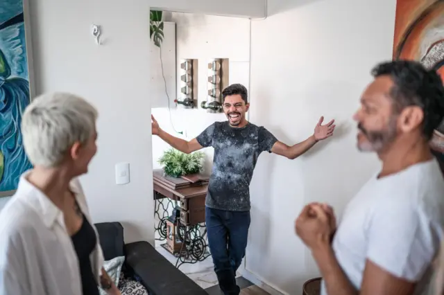 Un hombre saluda a dos personas
