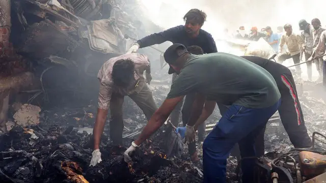 Autoridades de resgate trabalham no local onde o voo 171 da Air India caiu em uma área residencial perto do aeroporto de Ahmedabad em 12 de junho de 2025