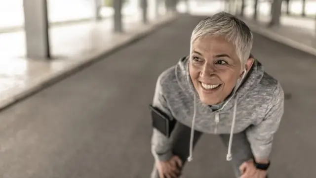 سيدة مبتسمة تمارس الرياضة.