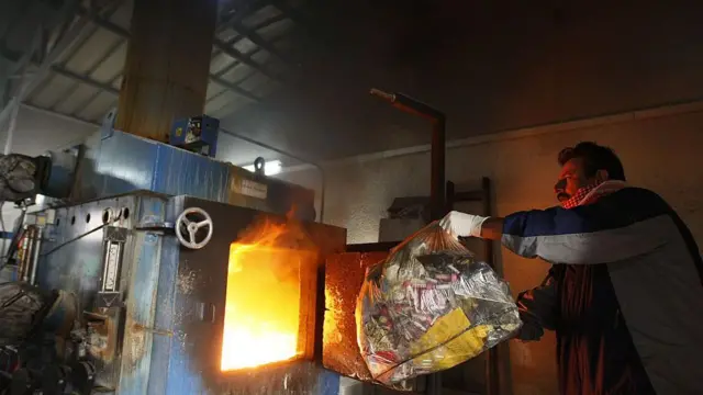 Палестинський працівник спалює відходи у сміттєспалювальному печі лікарні "Аль-Шифа" в місті Газа 13 грудня 2009 року.