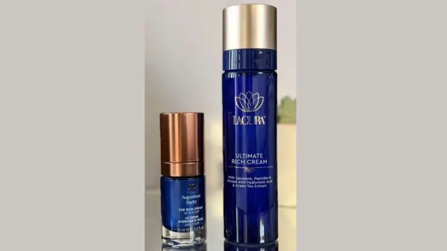 两瓶深蓝色的面霜摆放在桌上——一瓶是奥古斯丁·巴德(Augustinus Bader)的小容量产品,另一瓶是Lacura