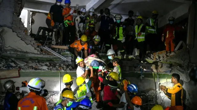 म्यान्मारको म्यान्डलेमा आइतवार एक व्यक्तिलाई भवनको भग्नावशेषबाट जीवितै बाहिर निकाल्दै उद्धारकर्मीहरू