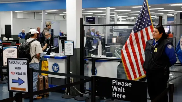 A Transportation Security Administration employee waits at a security checkpoint at the Hollywood Burbank Airport in Burbank, California