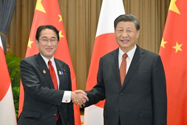Los líderes de Japón y China se dan la mano. 
