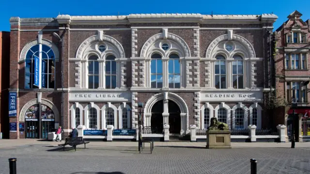 Museo y Galería de Arte South Shields: es un edificio de ladrillo marrón con numerosos arcos de ventanas blancas. Hay una estatua de un león en el frente, de un tono verde musgo. Parte del ladrillo blanco pintado del lugar indica biblioteca y sala de lectura gratuitas.