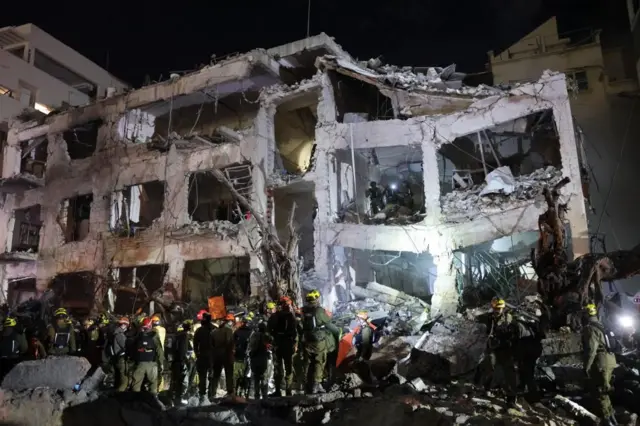 Rescatistas en un edificio residencial destruido en Tel Aviv