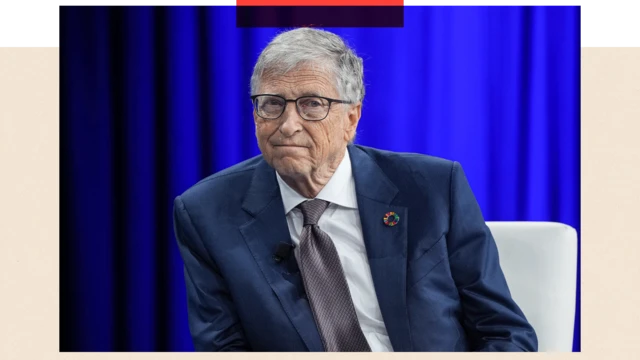 Bill Gates öltönyben ül egy fehér széken, a háttérben kék függöny.