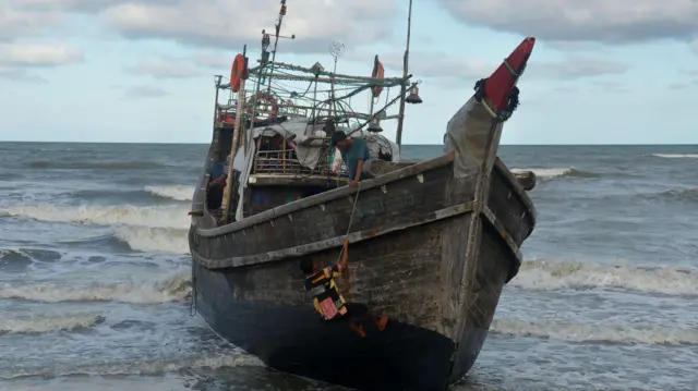 Warga memeriksa kapal pengangkut imigran etnis Rohingya yang mendarat di desa Kulee, kecamatan Batee, Kabupaten Pidie, Aceh, Minggu (19/11/2023).