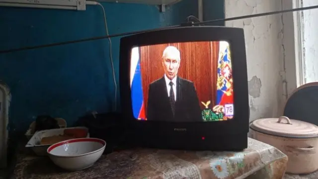 Poutine vu à travers l'écran d'une télévision en train de faire un discours