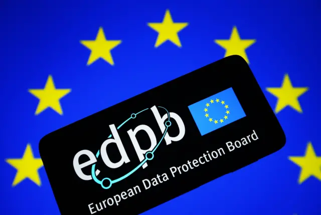 На фоне синего флага с желтыми звездами, расположенными по кругу, - силуэт смартфона. На нем - изображение такого же синего флага с желтыми звездами по кругу и надпись EDPB и European Data Protection Board.